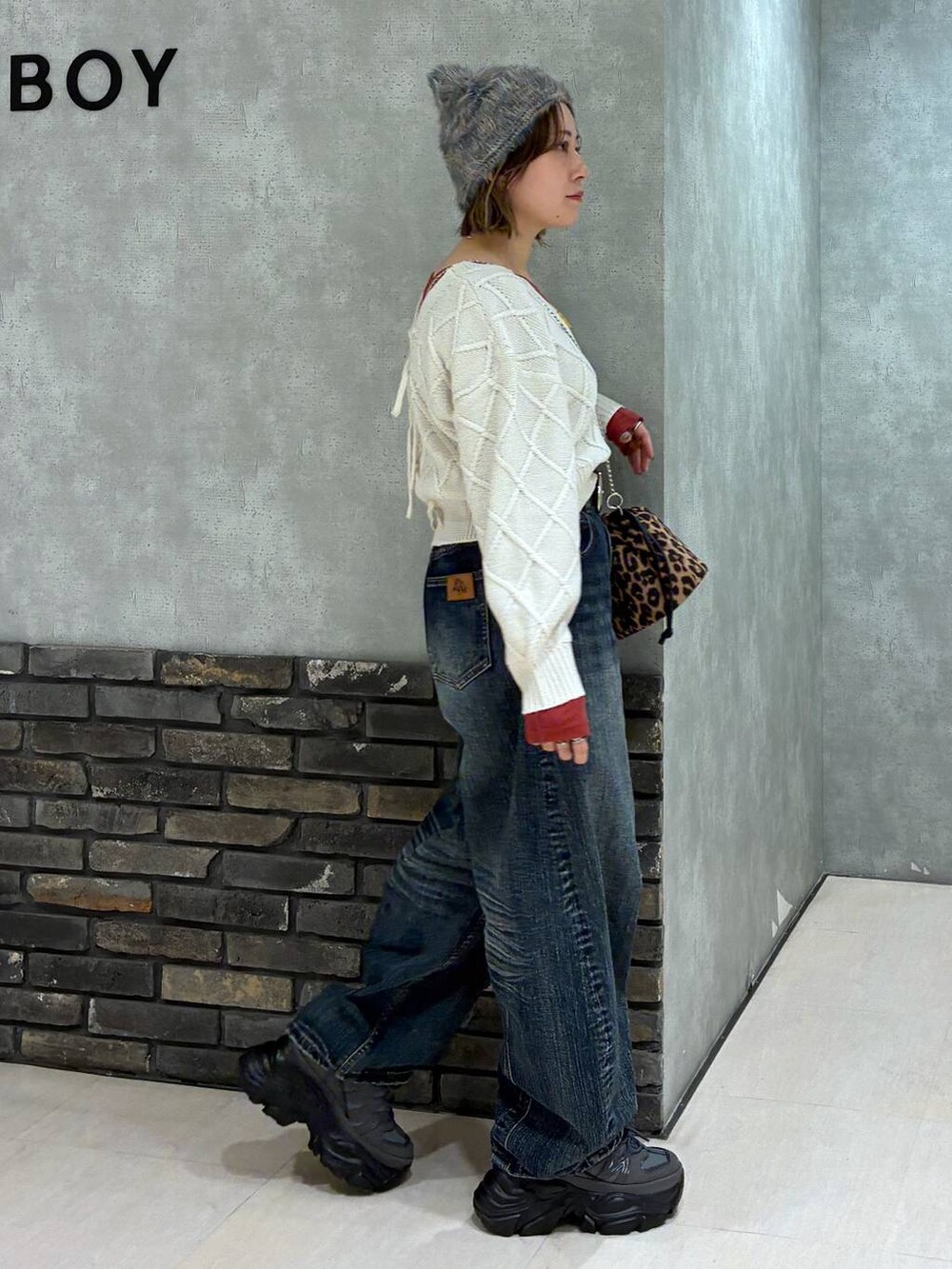 グレー系のスニーカー、ブルー系のデニムパンツ、ホワイト系のニット/セーターを着用したレディースの秋コーディネートの2枚目の写真