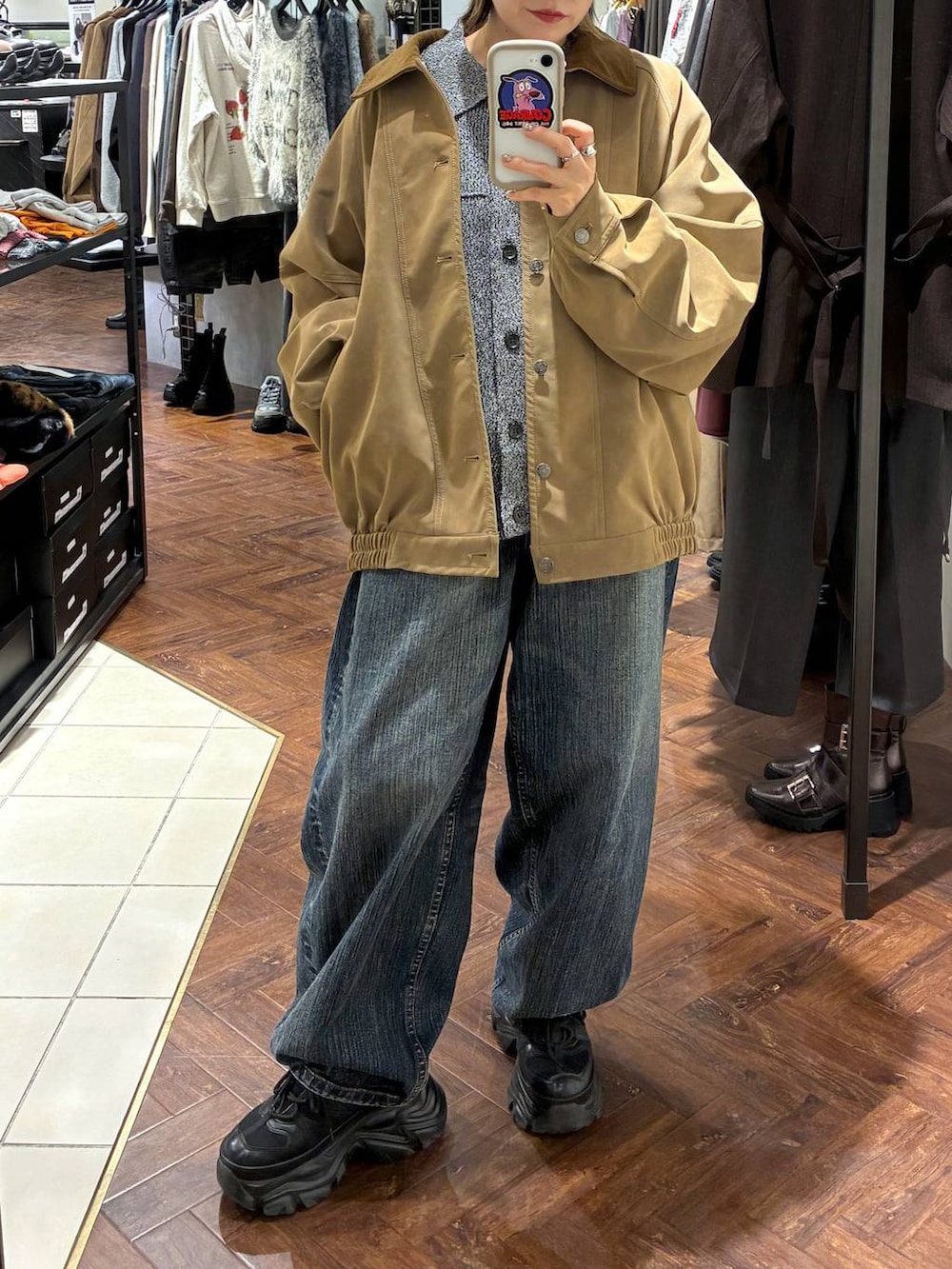 ブラック系のスニーカー、ベージュ系のブルゾン、ブラック系のブルゾンを着用したレディースの秋コーディネートの3枚目の写真