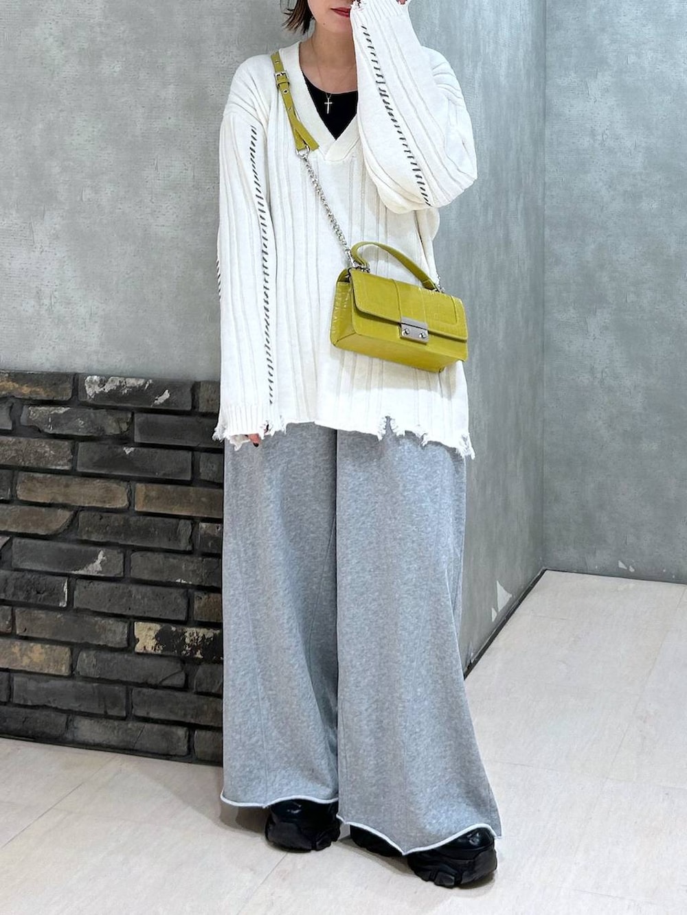 ブラック系のスニーカー、グレー系のスウェットパンツ、イエロー系のハンドバッグを着用したレディースの秋コーディネートの3枚目の写真