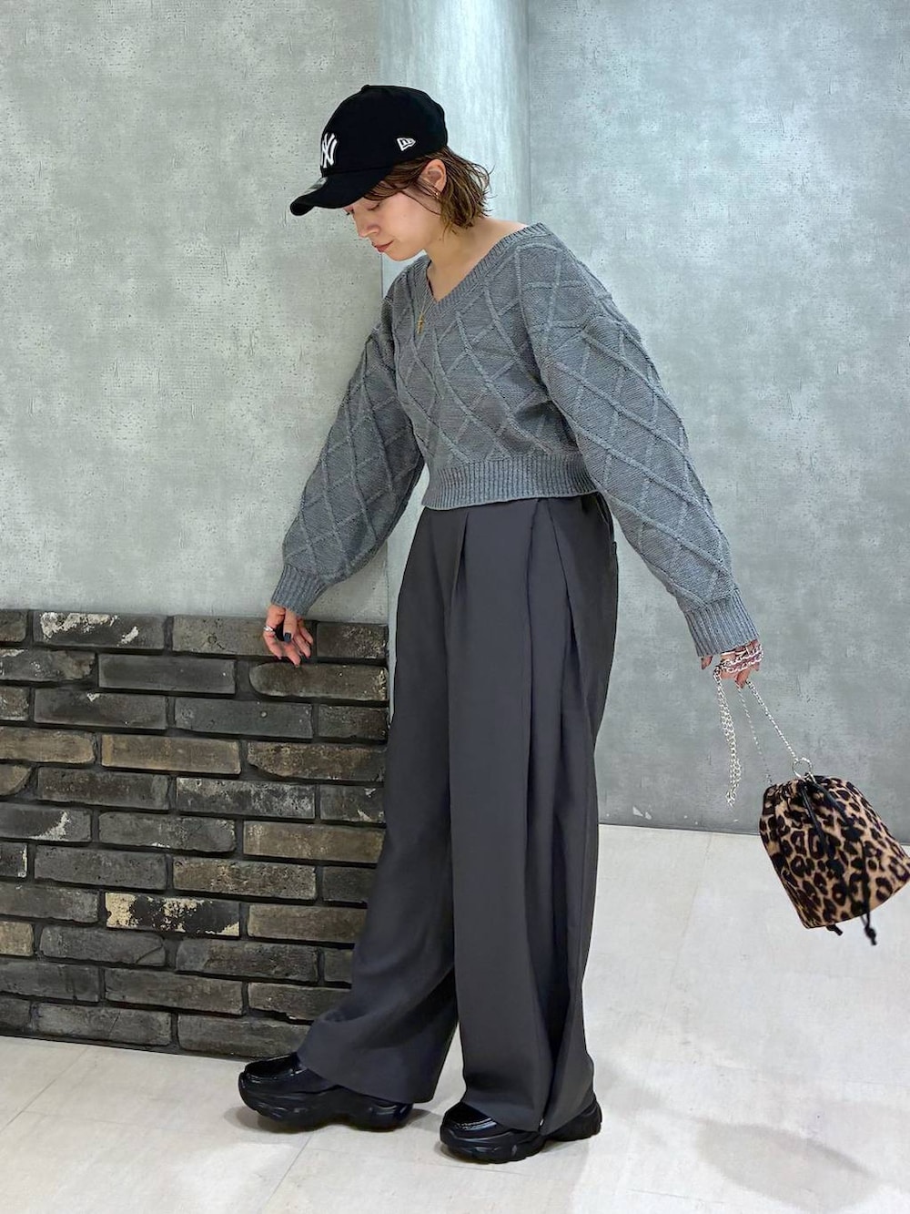 グレー系のスラックス、グレー系のニット/セーター、その他のハンドバッグを着用したレディースの秋コーディネートの5枚目の写真