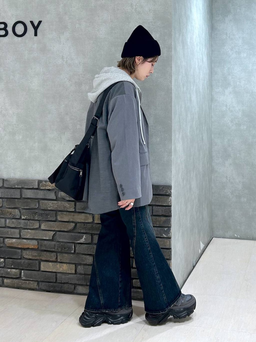 グレー系のスニーカー、ブルー系のデニムパンツ、グレー系のテーラードジャケットを着用したレディースの秋コーディネートの3枚目の写真