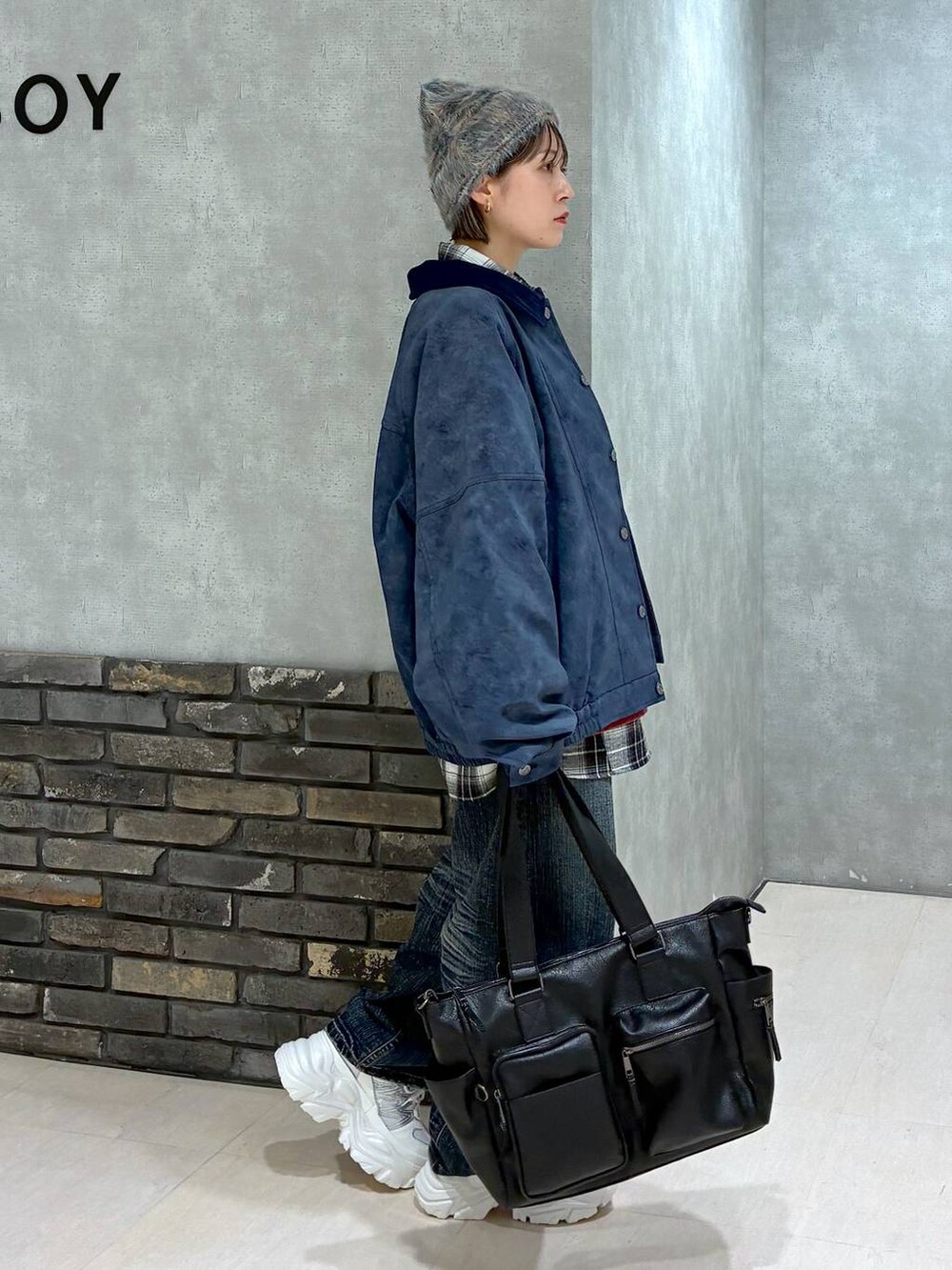 ホワイト系のスニーカー、ブラック系のボストンバッグ、レッド系のスウェットを着用したレディースの冬コーディネートの4枚目の写真