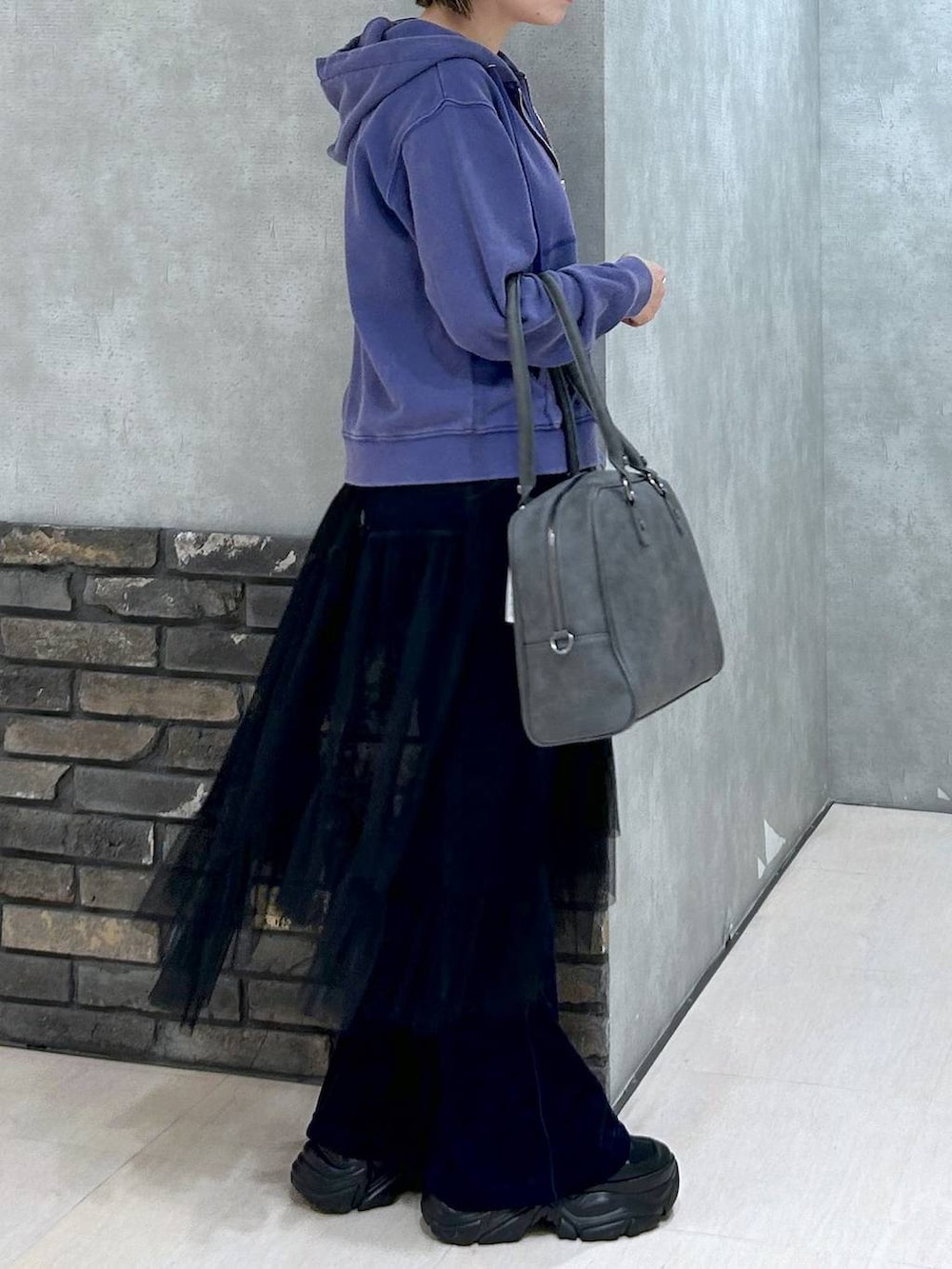 ブラック系のスニーカー、グレー系のボストンバッグ、ブラック系のキャミソールを着用したレディースの秋コーディネートの4枚目の写真