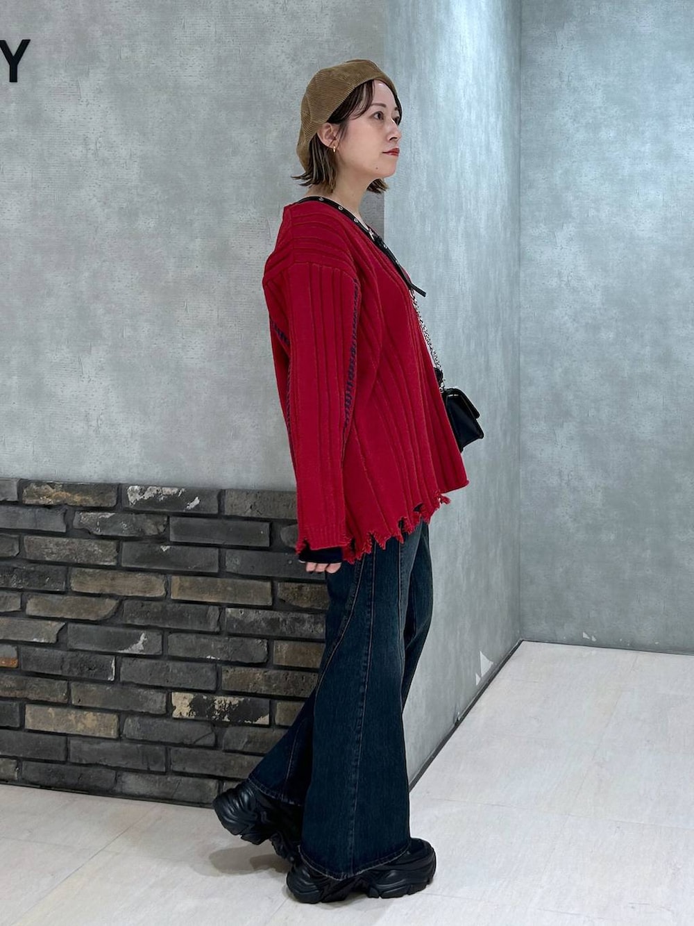 ブラック系のスニーカー、ブルー系のデニムパンツ、その他のハンドバッグを着用したレディースの秋コーディネートの2枚目の写真