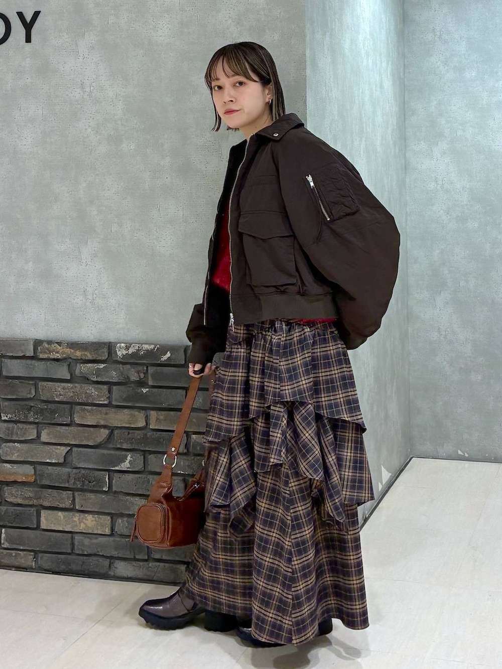 その他のブーツ、ブラウン系のスカート、ブラウン系のショルダーバッグを着用したレディースの冬コーディネートの9枚目の写真