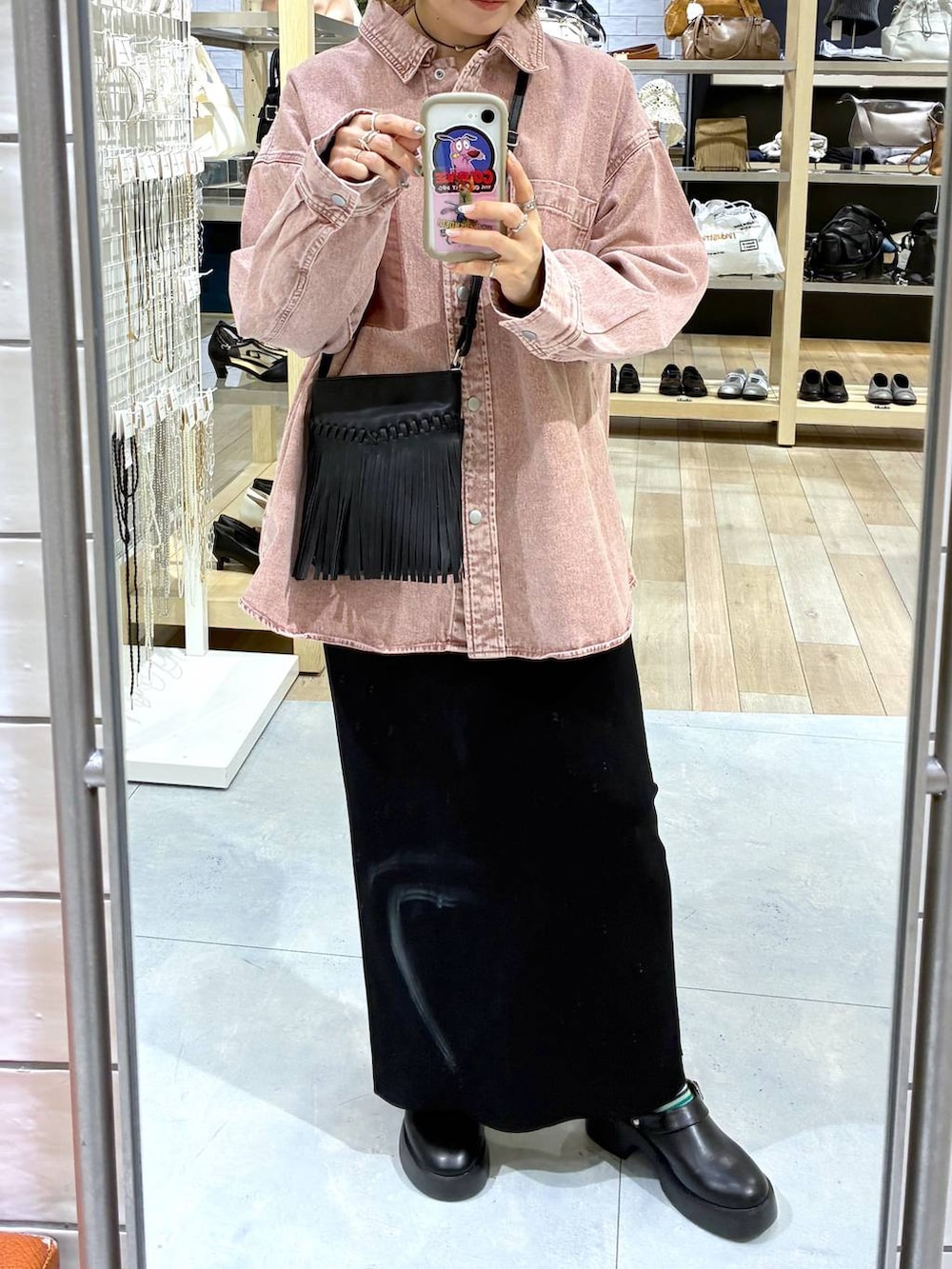 ブラック系のスカート、ブラック系のサンダル、ピンク系のシャツ/ブラウスを着用したレディースの春コーディネートの3枚目の写真