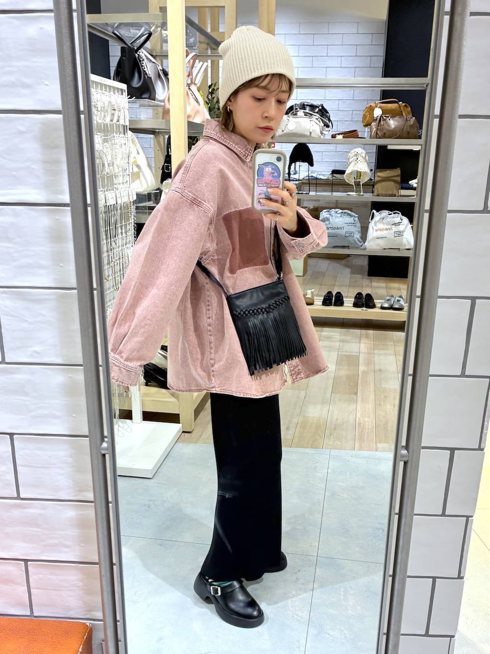 ブラック系のスカート、ブラック系のサンダル、ピンク系のシャツ/ブラウスを着用したレディースの春コーディネートの2枚目の写真