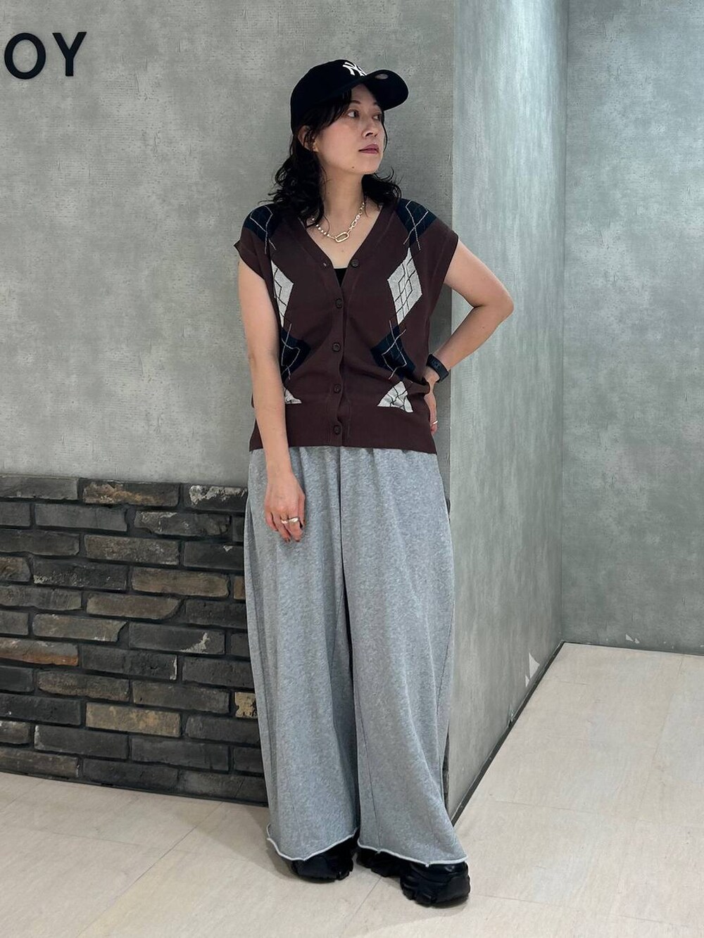 ブラック系のスニーカー、ブラック系のキャミソール、グレー系のスウェットパンツを着用したレディースの秋コーディネートの2枚目の写真