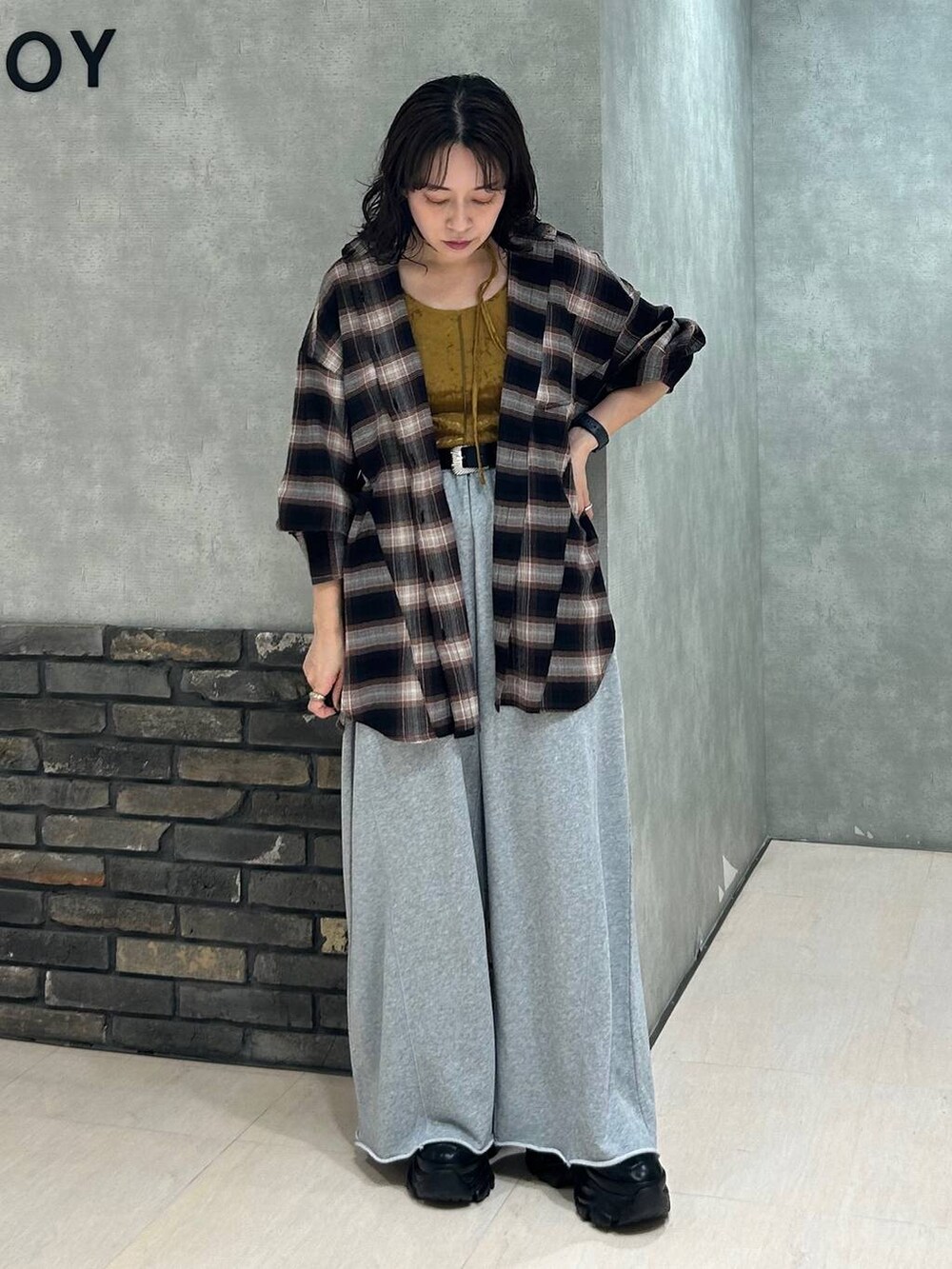 ブラック系のスニーカー、グレー系のスウェットパンツ、ブラウン系のシャツ/ブラウスを着用したレディースの秋コーディネートの2枚目の写真