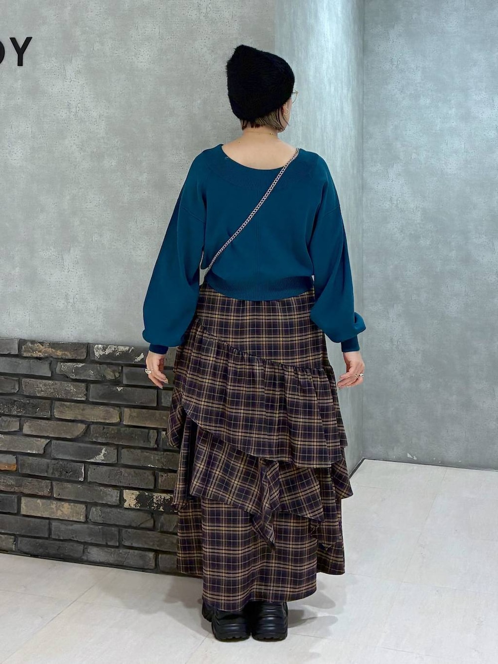 ブラック系のブーツ、ブラウン系のスカート、グリーン系のニット/セーターを着用したレディースの冬コーディネートの3枚目の写真