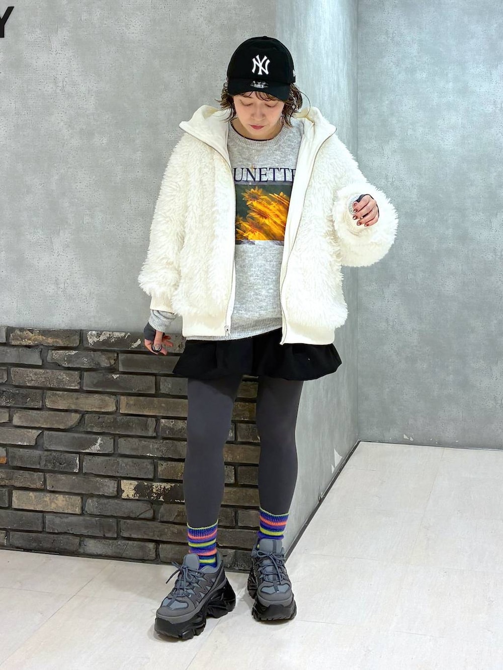 グレー系のスニーカー、ホワイト系のブルゾン、ブラック系のその他パンツを着用したレディースの冬コーディネートの2枚目の写真