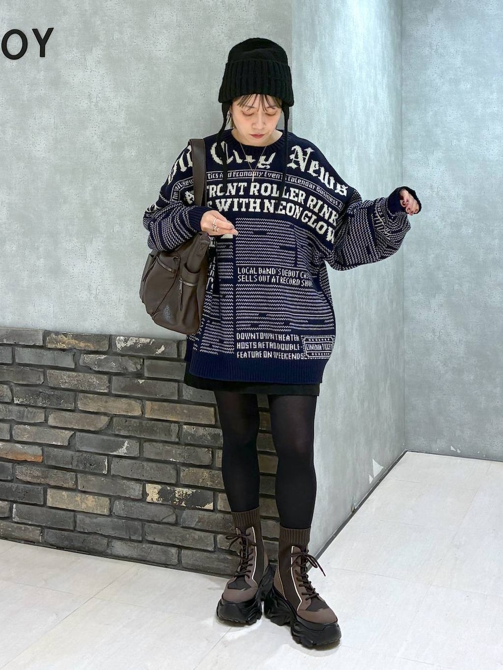 ブラウン系のブーツ、ブラウン系のボストンバッグ、ブラック系のスカートを着用したレディースの冬コーディネートの9枚目の写真