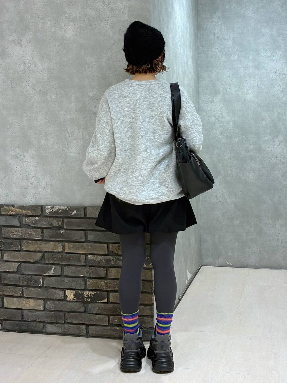 グレー系のスニーカー、ブラック系のボストンバッグ、ブラック系のその他パンツを着用したレディースの冬コーディネートの3枚目の写真