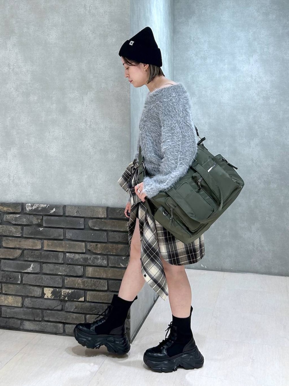 ブラック系のブーツ、グリーン系のボストンバッグ、ブラック系のその他パンツを着用したレディースの秋コーディネートの6枚目の写真