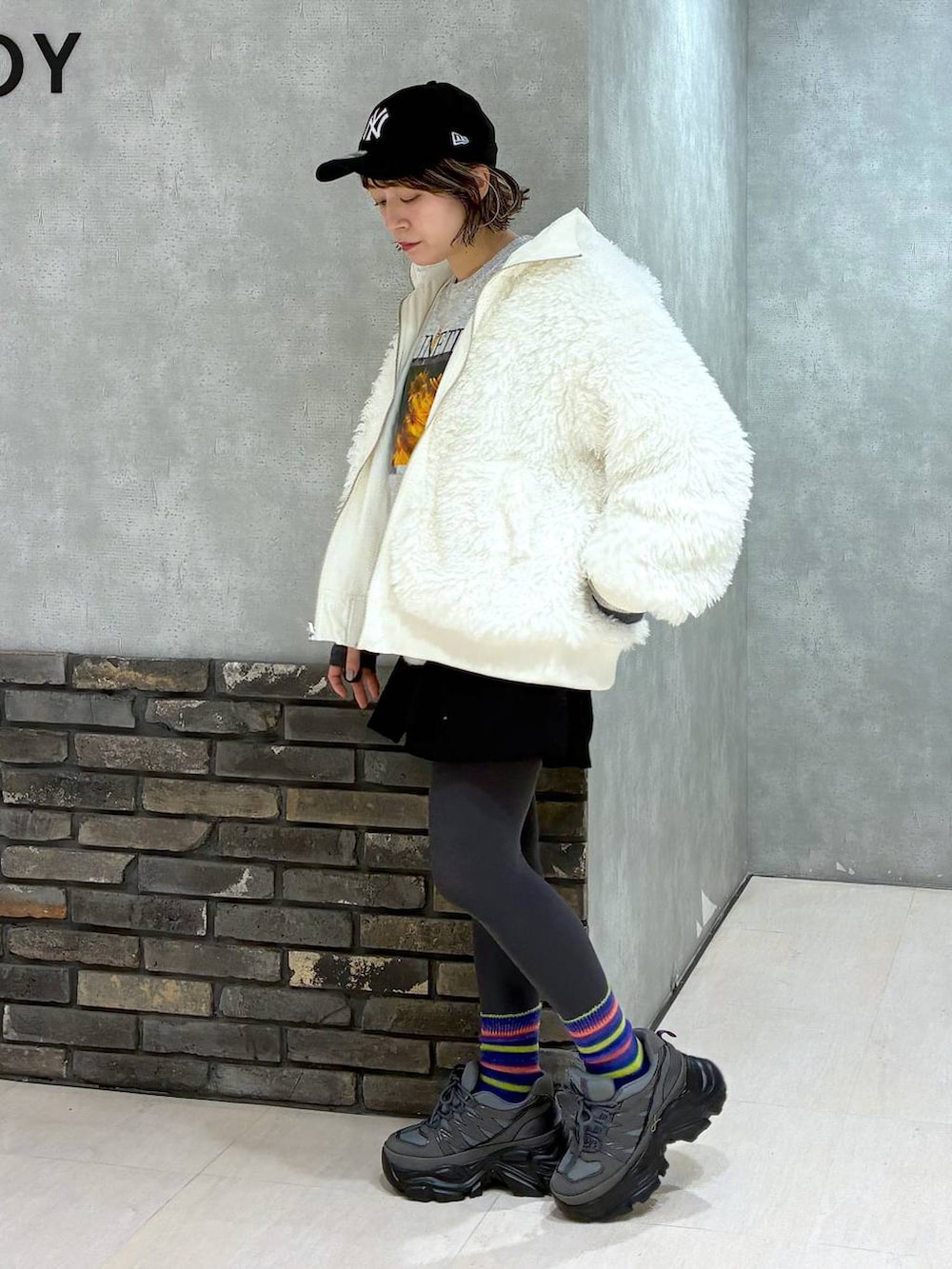 グレー系のスニーカー、ホワイト系のブルゾン、ブラック系のその他パンツを着用したレディースの冬コーディネートの8枚目の写真