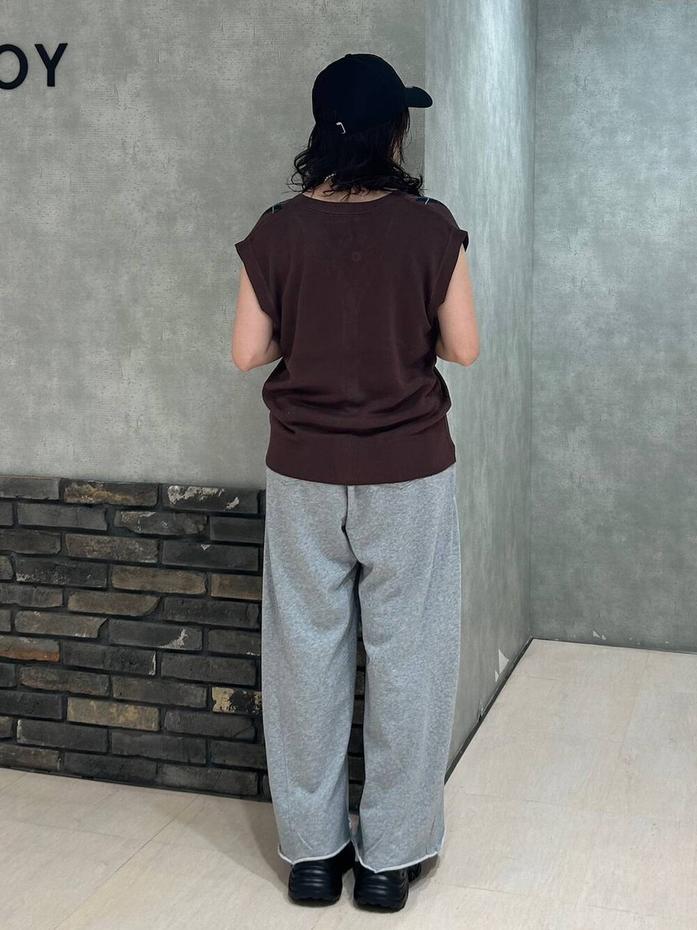 ブラック系のスニーカー、ブラック系のキャミソール、グレー系のスウェットパンツを着用したレディースの秋コーディネートの6枚目の写真