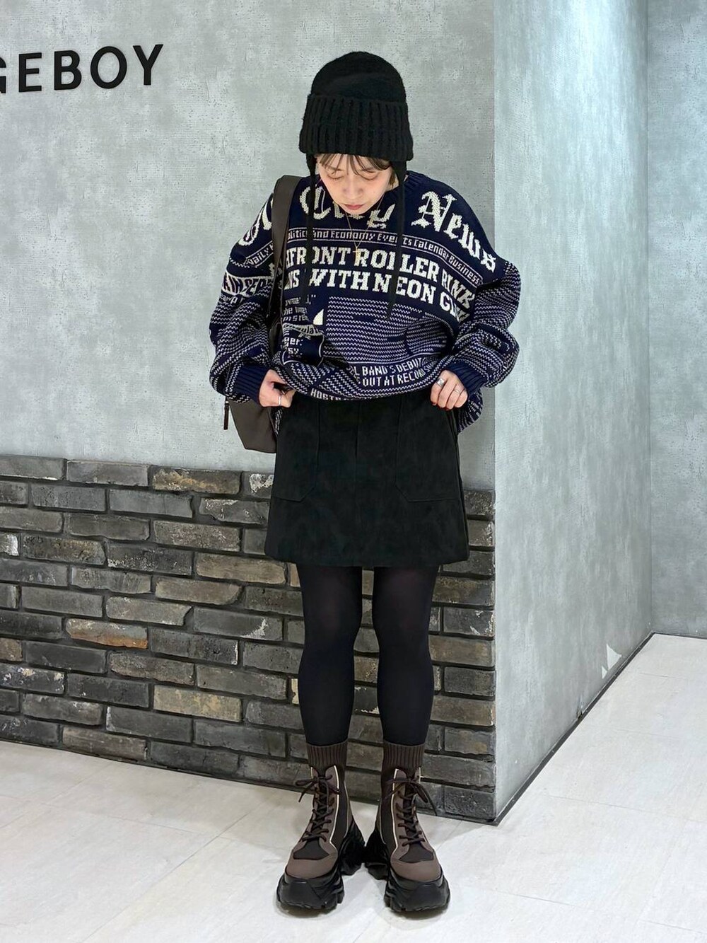 ブラウン系のブーツ、ブラウン系のボストンバッグ、ブラック系のスカートを着用したレディースの冬コーディネートの8枚目の写真