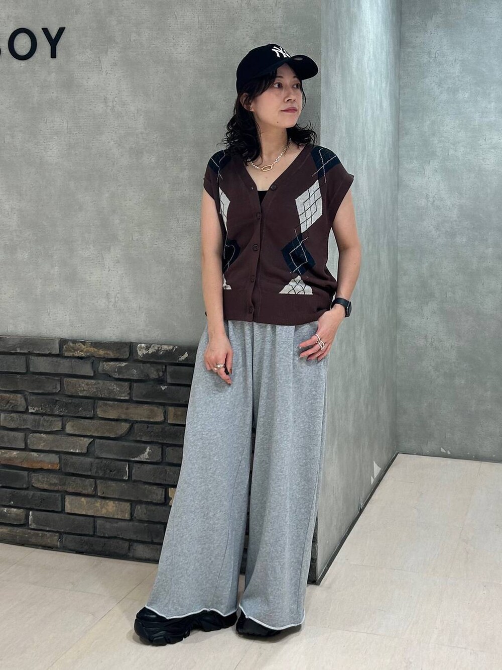 ブラック系のスニーカー、ブラック系のキャミソール、グレー系のスウェットパンツを着用したレディースの秋コーディネートの7枚目の写真