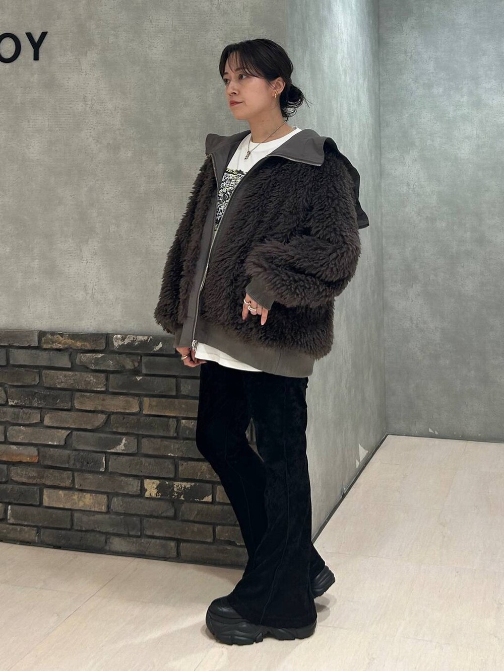 ブラック系のスニーカー、ブラウン系のブルゾン、ブラック系のその他パンツを着用したレディースの秋コーディネートの4枚目の写真