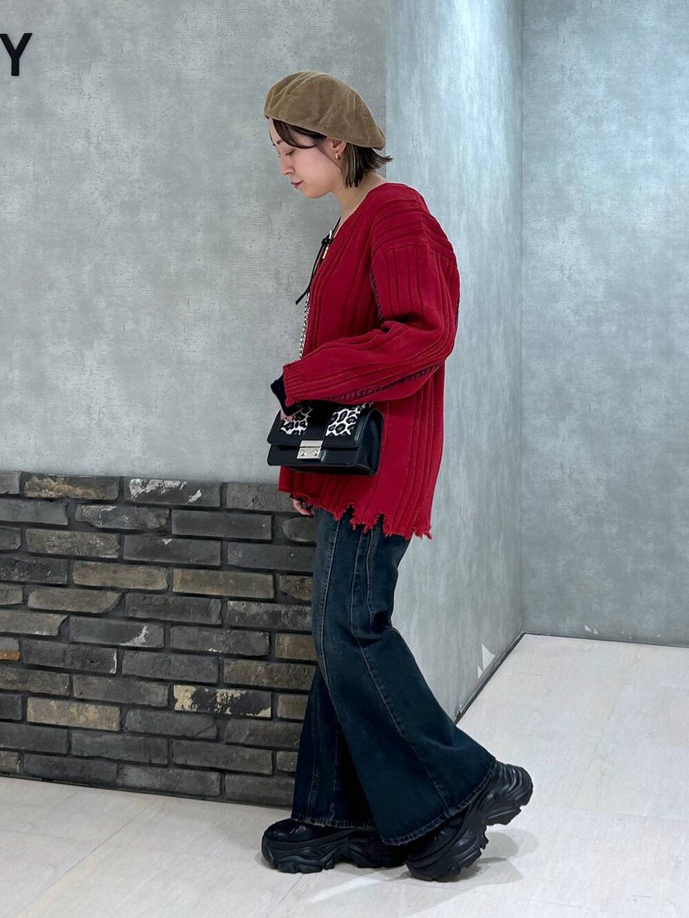 ブラック系のスニーカー、ブルー系のデニムパンツ、その他のハンドバッグを着用したレディースの秋コーディネートの4枚目の写真