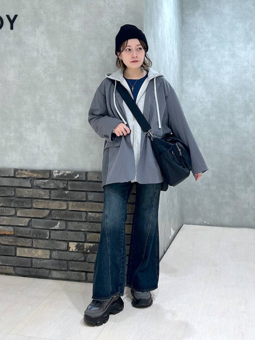 グレー系のスニーカー、ブルー系のデニムパンツ、グレー系のテーラードジャケットを着用したレディースの秋コーディネートの8枚目の写真