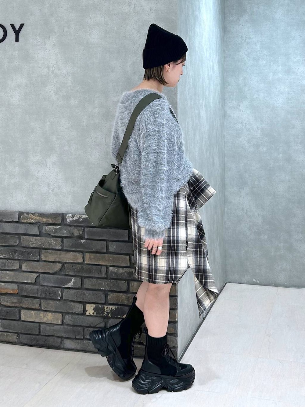 ブラック系のブーツ、グリーン系のボストンバッグ、ブラック系のその他パンツを着用したレディースの秋コーディネートの3枚目の写真