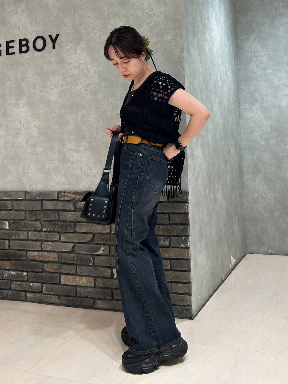 ブラック系のスニーカー、グレー系のタンクトップ、ブルー系のデニムパンツを着用したレディースの夏コーディネートの4枚目の写真