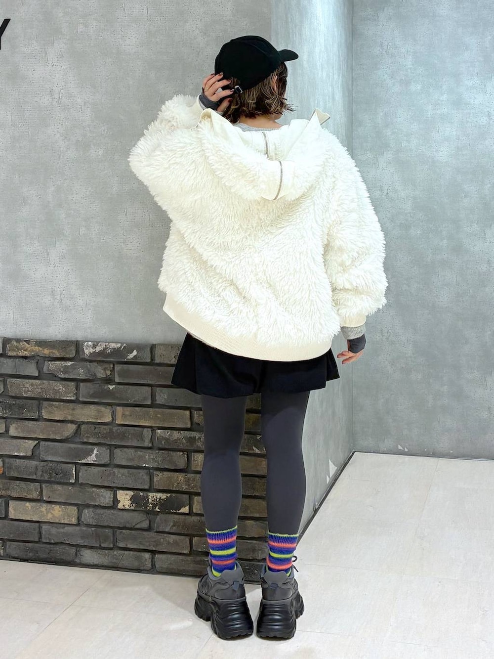 グレー系のスニーカー、ホワイト系のブルゾン、ブラック系のその他パンツを着用したレディースの冬コーディネートの6枚目の写真