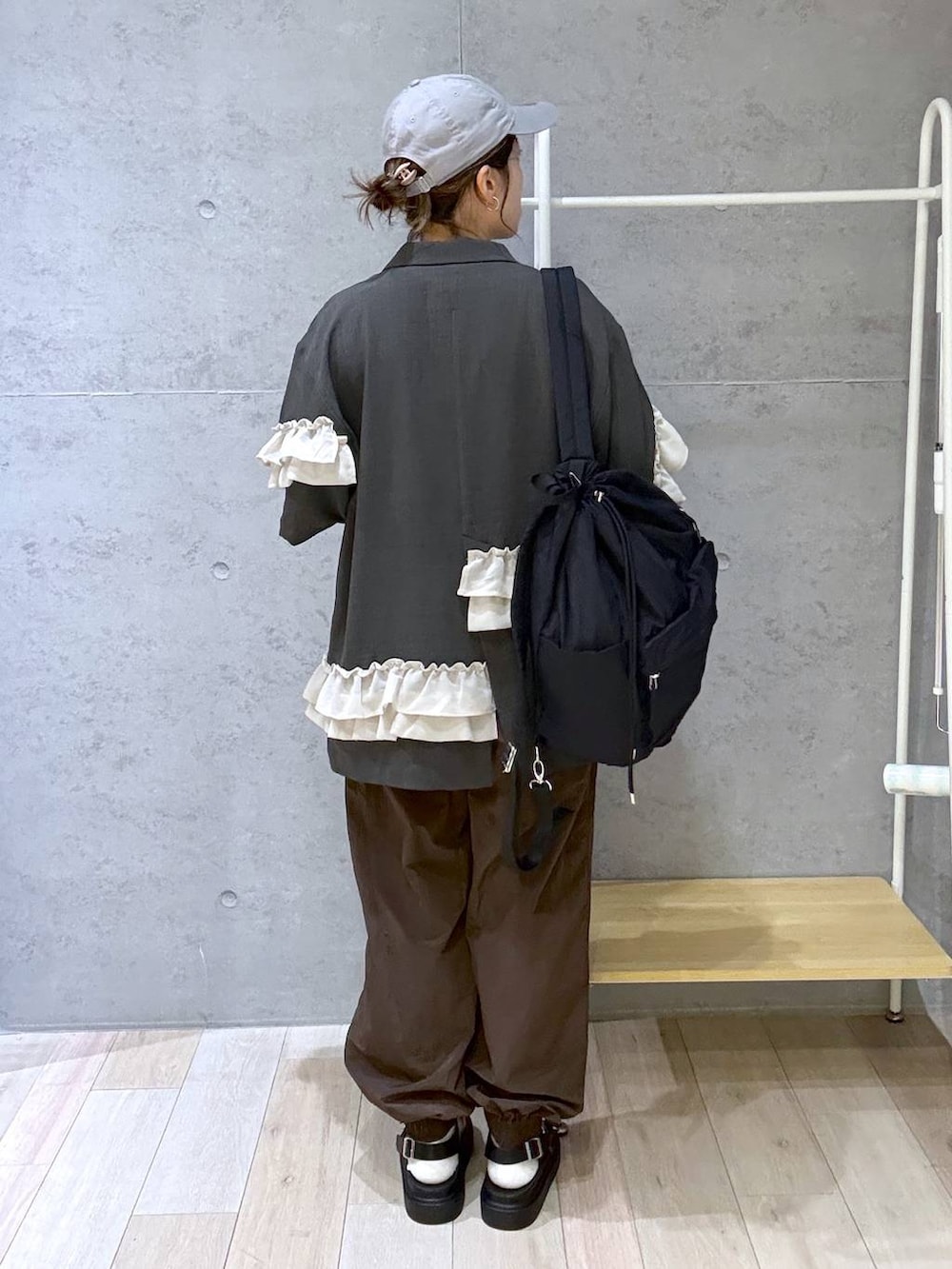 ベージュ系のTシャツ/カットソー、ブラック系のサンダル、ブラック系のバックパック/リュックを着用したレディースの春コーディネートの4枚目の写真