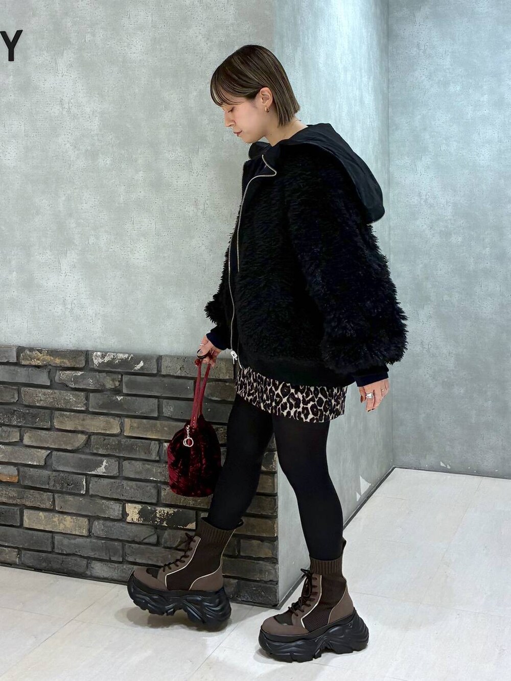 ブラウン系のブーツ、ブラック系のブルゾン、ブラウン系のスカートを着用したレディースの冬コーディネートの4枚目の写真