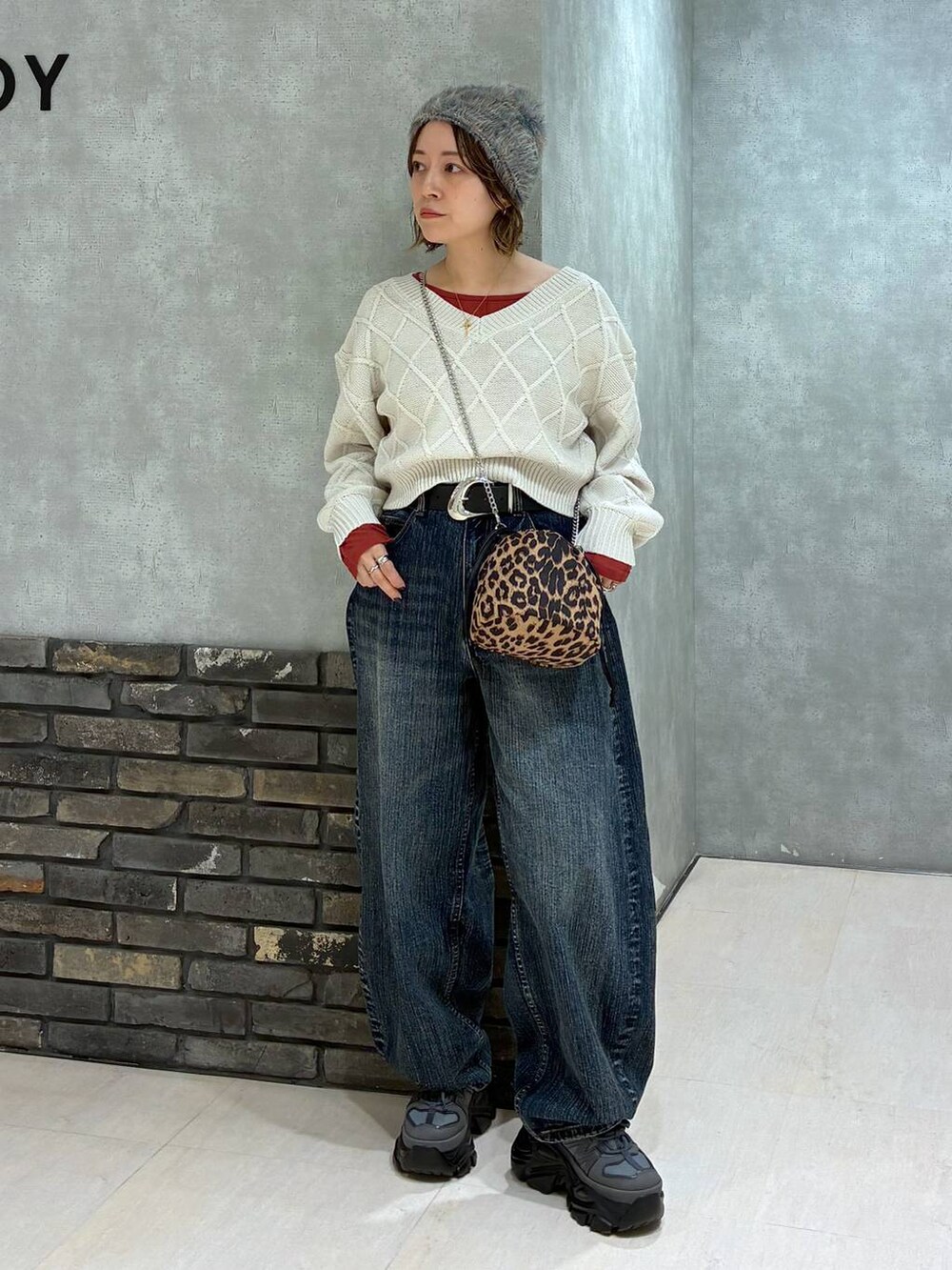 グレー系のスニーカー、ブルー系のデニムパンツ、ホワイト系のニット/セーターを着用したレディースの秋コーディネートの6枚目の写真