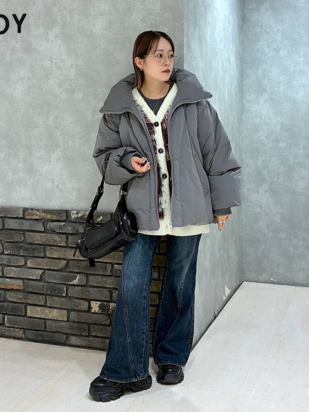 ブラック系のスニーカー、ブルー系のデニムパンツ、グレー系のブルゾンを着用したレディースの冬コーディネートの2枚目の写真