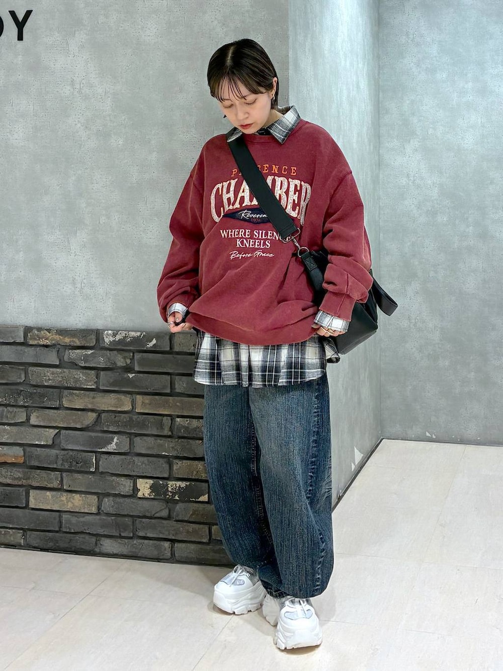 ホワイト系のスニーカー、ブラック系のボストンバッグ、レッド系のスウェットを着用したレディースの冬コーディネートの5枚目の写真