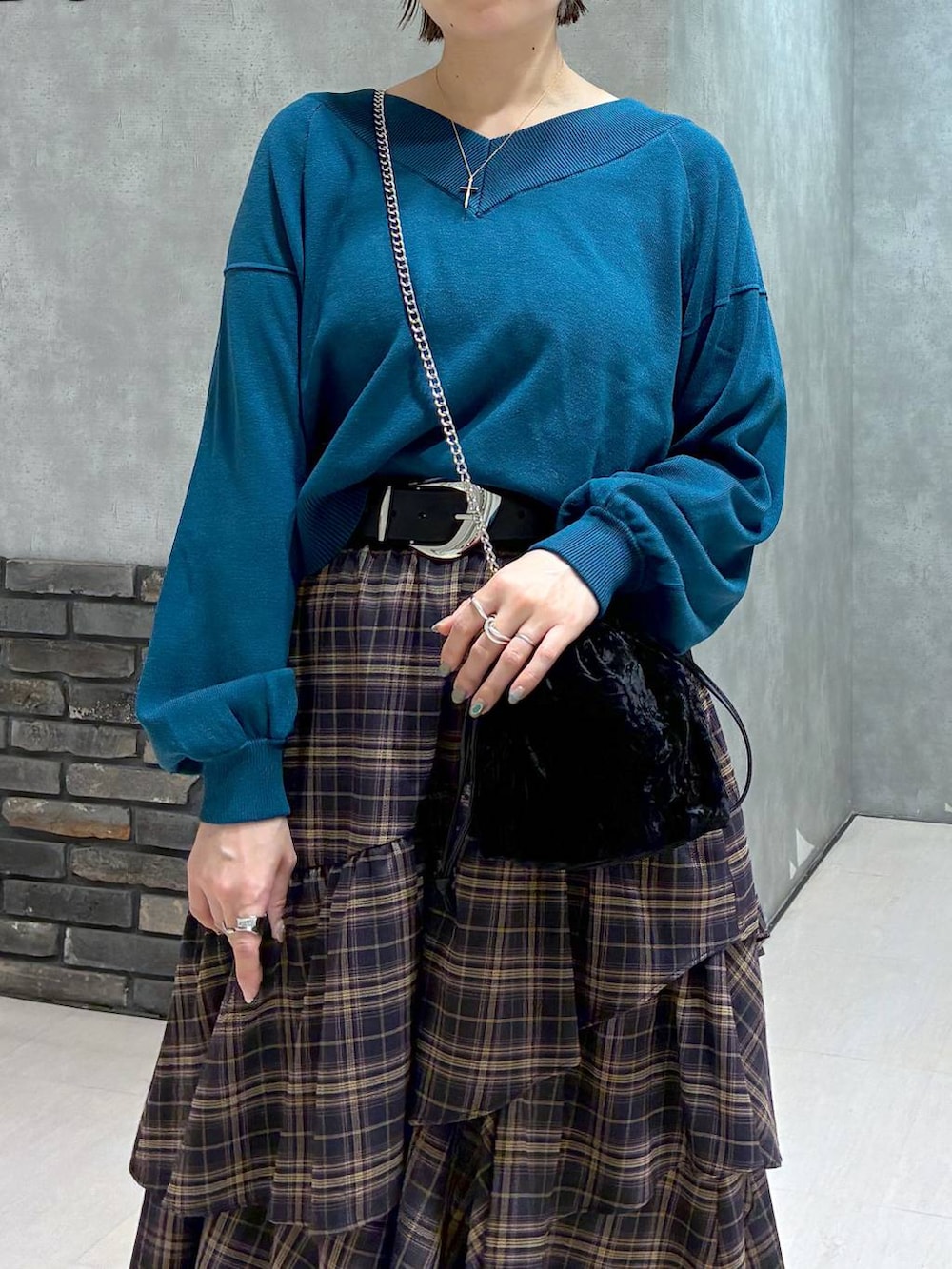 ブラック系のブーツ、ブラウン系のスカート、グリーン系のニット/セーターを着用したレディースの冬コーディネートの7枚目の写真