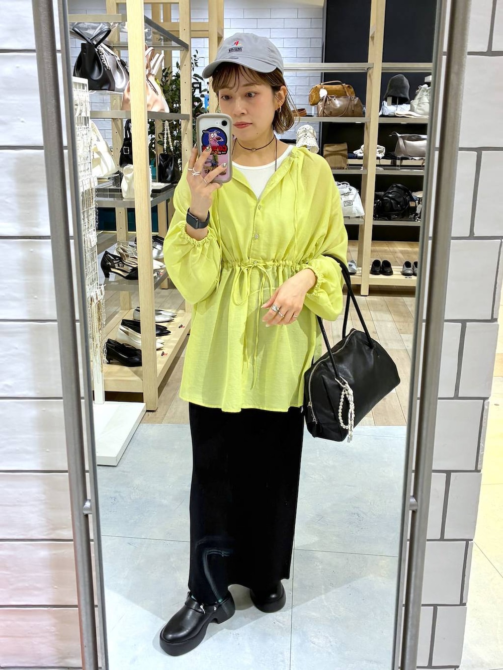 ブラック系のスカート、ブラック系のサンダル、ブラック系のボストンバッグを着用したレディースの春コーディネートの2枚目の写真