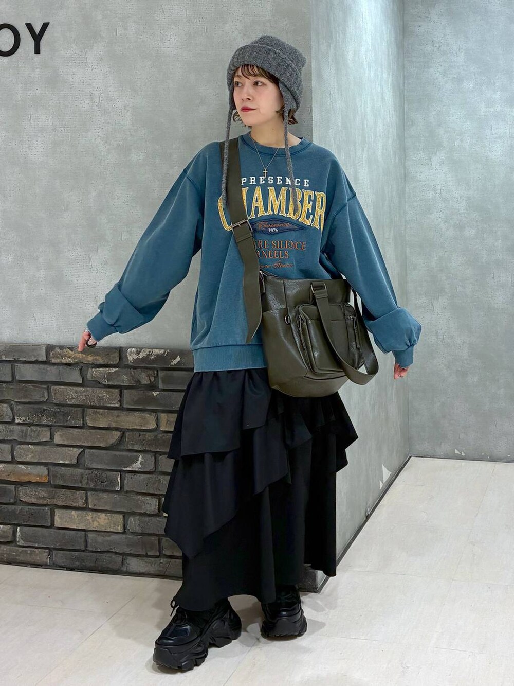 ブラック系のスニーカー、グリーン系のボストンバッグ、グリーン系のスウェットを着用したレディースの冬コーディネートの2枚目の写真