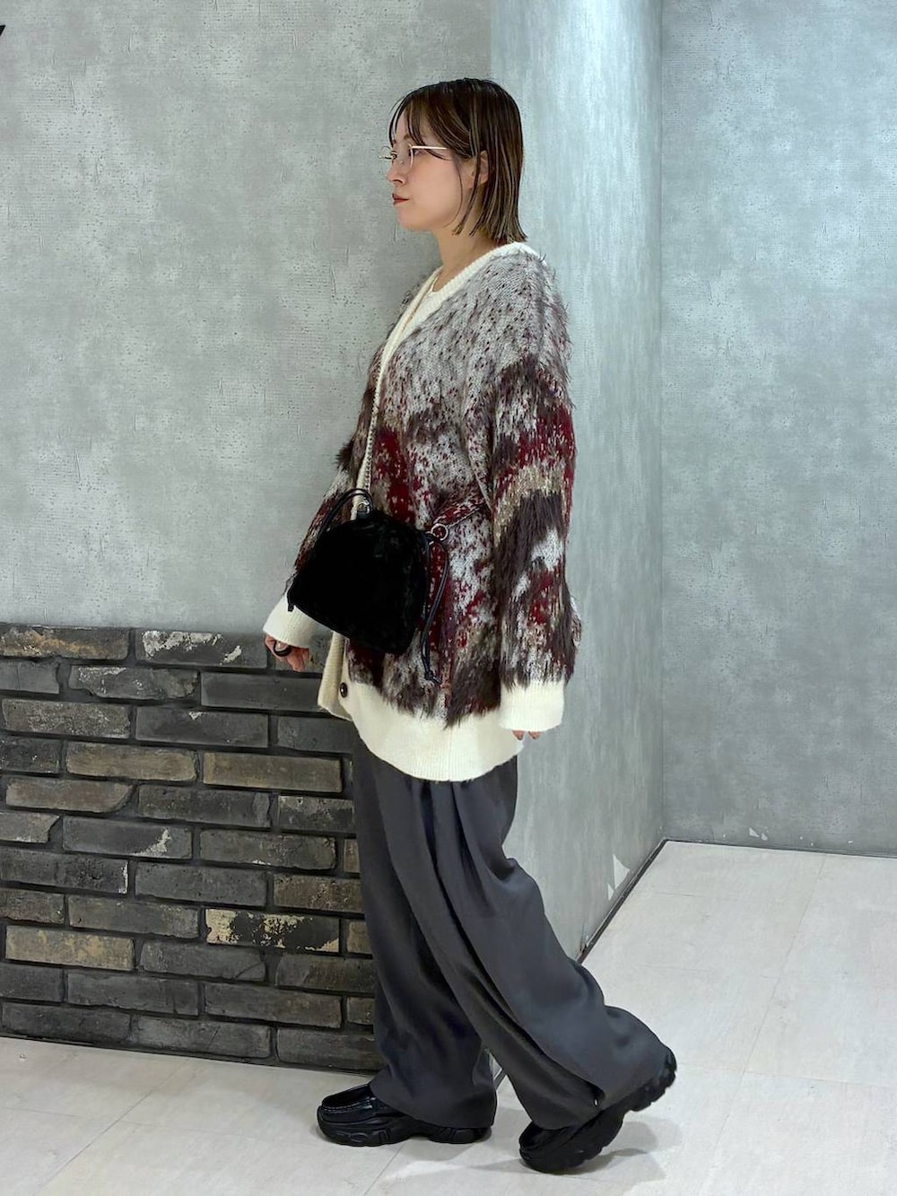 ホワイト系のTシャツ/カットソー、ホワイト系のカーディガン/ボレロ、グレー系のスラックスを着用したレディースの秋コーディネートの4枚目の写真