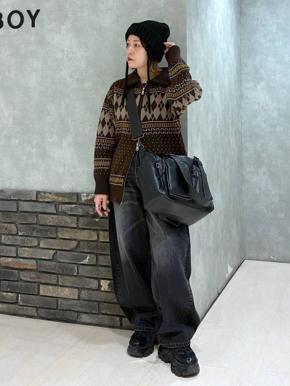 ブラック系のスニーカー、ブラック系のボストンバッグ、ブラック系のデニムパンツを着用したレディースの冬コーディネートの7枚目の写真