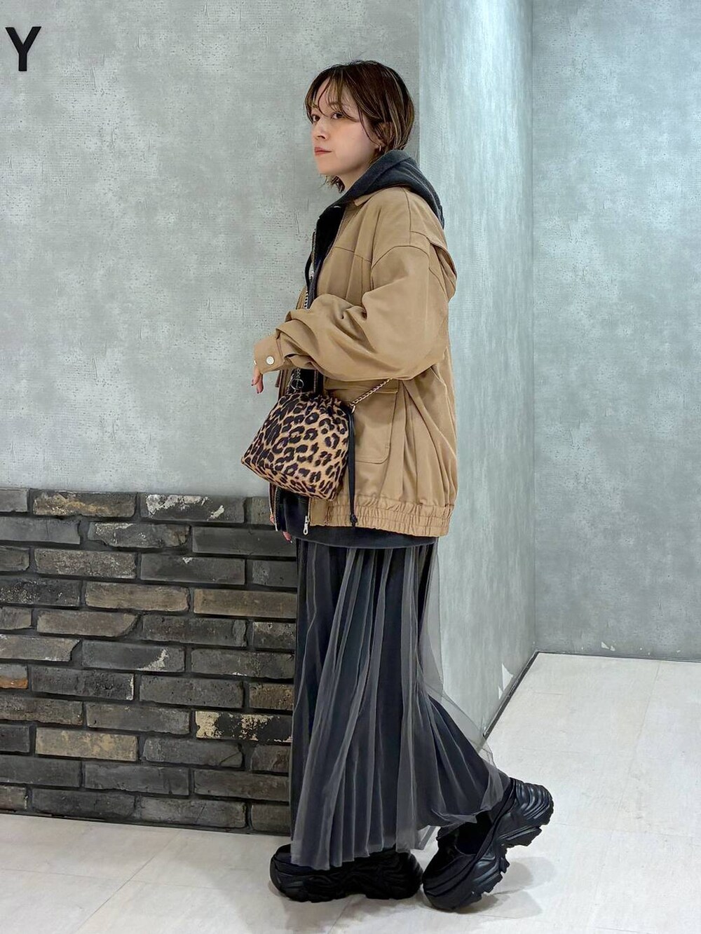 ブラック系のブーツ、イエロー系のブルゾン、ブラック系のパーカーを着用したレディースの秋コーディネートの5枚目の写真