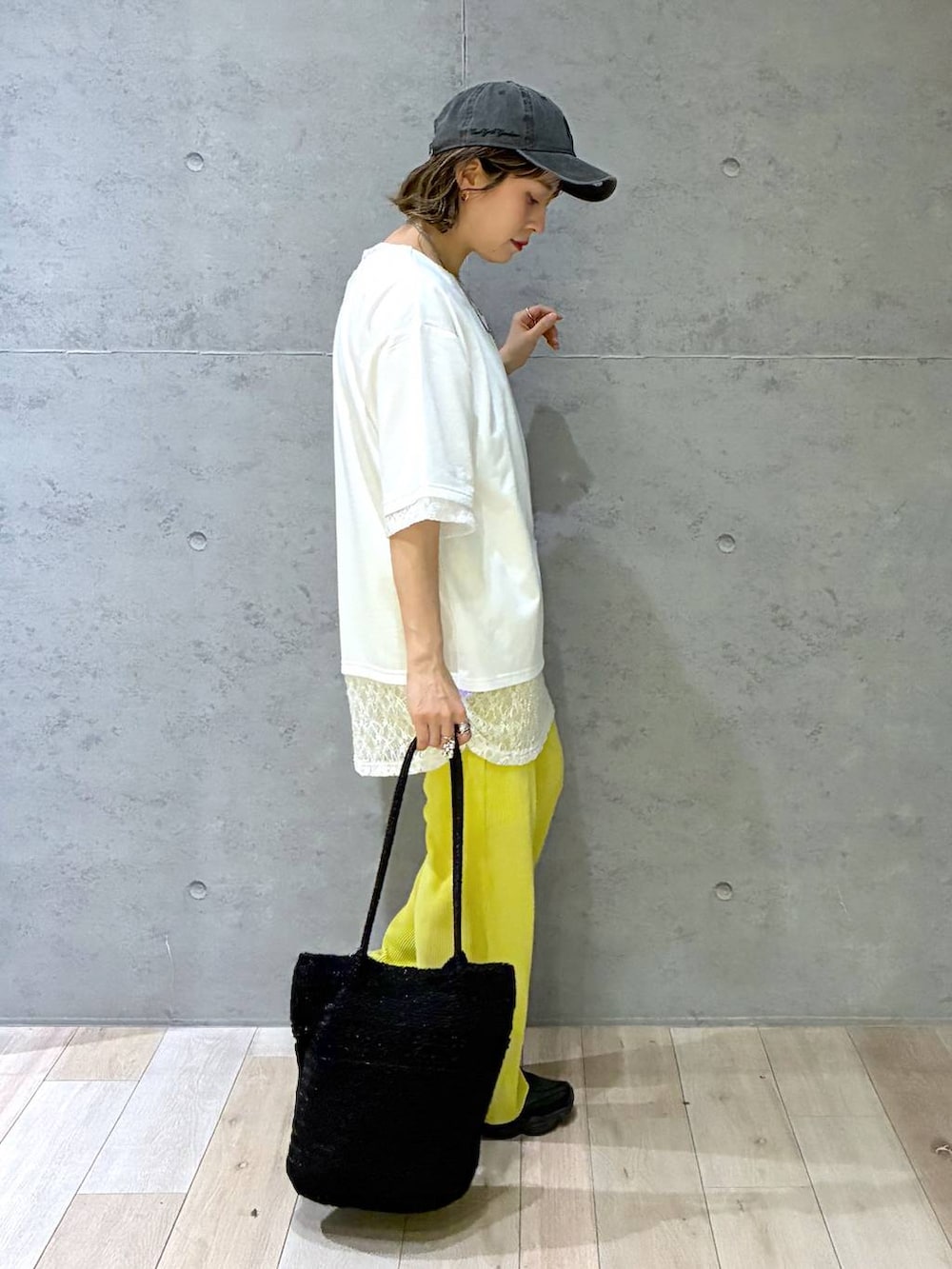 イエロー系のその他パンツ、ブラック系のショルダーバッグ、ホワイト系のTシャツ/カットソーを着用したレディースの春コーディネートの5枚目の写真