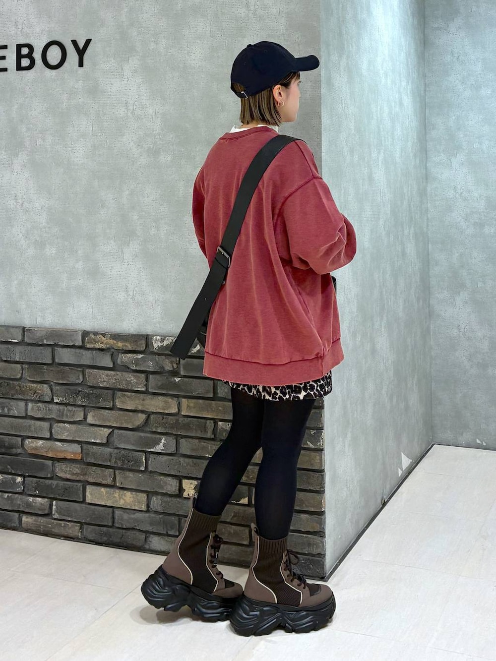 ブラウン系のブーツ、ブラック系のボストンバッグ、レッド系のスウェットを着用したレディースの冬コーディネートの5枚目の写真