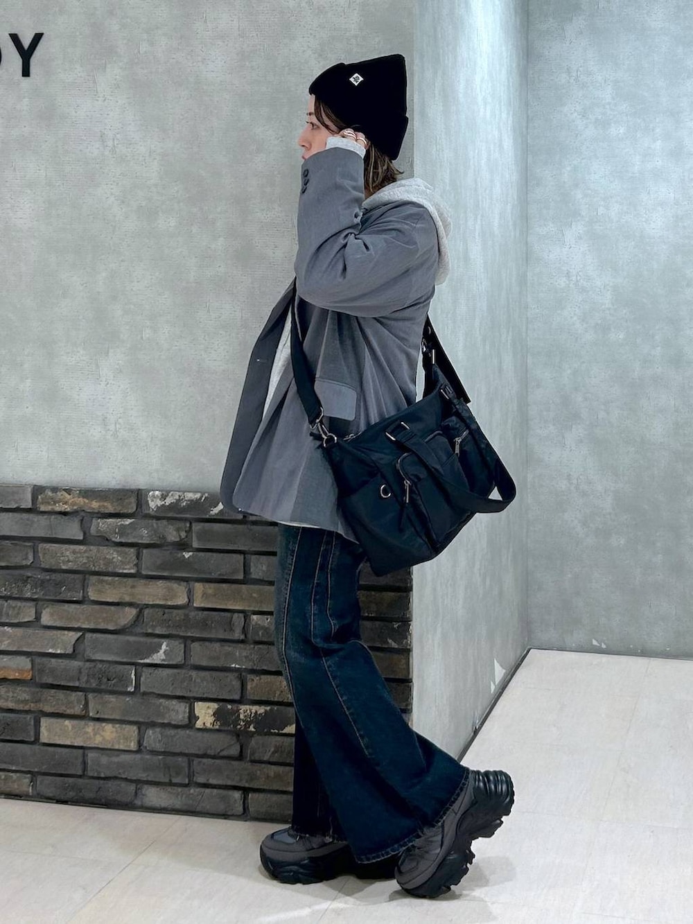 グレー系のスニーカー、ブルー系のデニムパンツ、グレー系のテーラードジャケットを着用したレディースの秋コーディネートの6枚目の写真