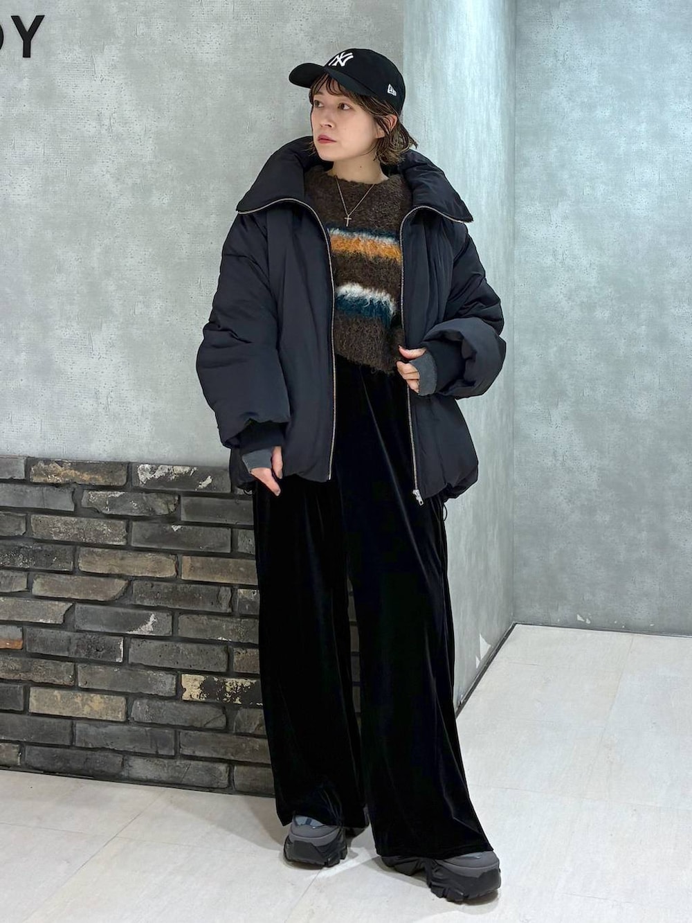 グレー系のスニーカー、ブラック系のブルゾン、ブラック系のその他パンツを着用したレディースの冬コーディネートの6枚目の写真