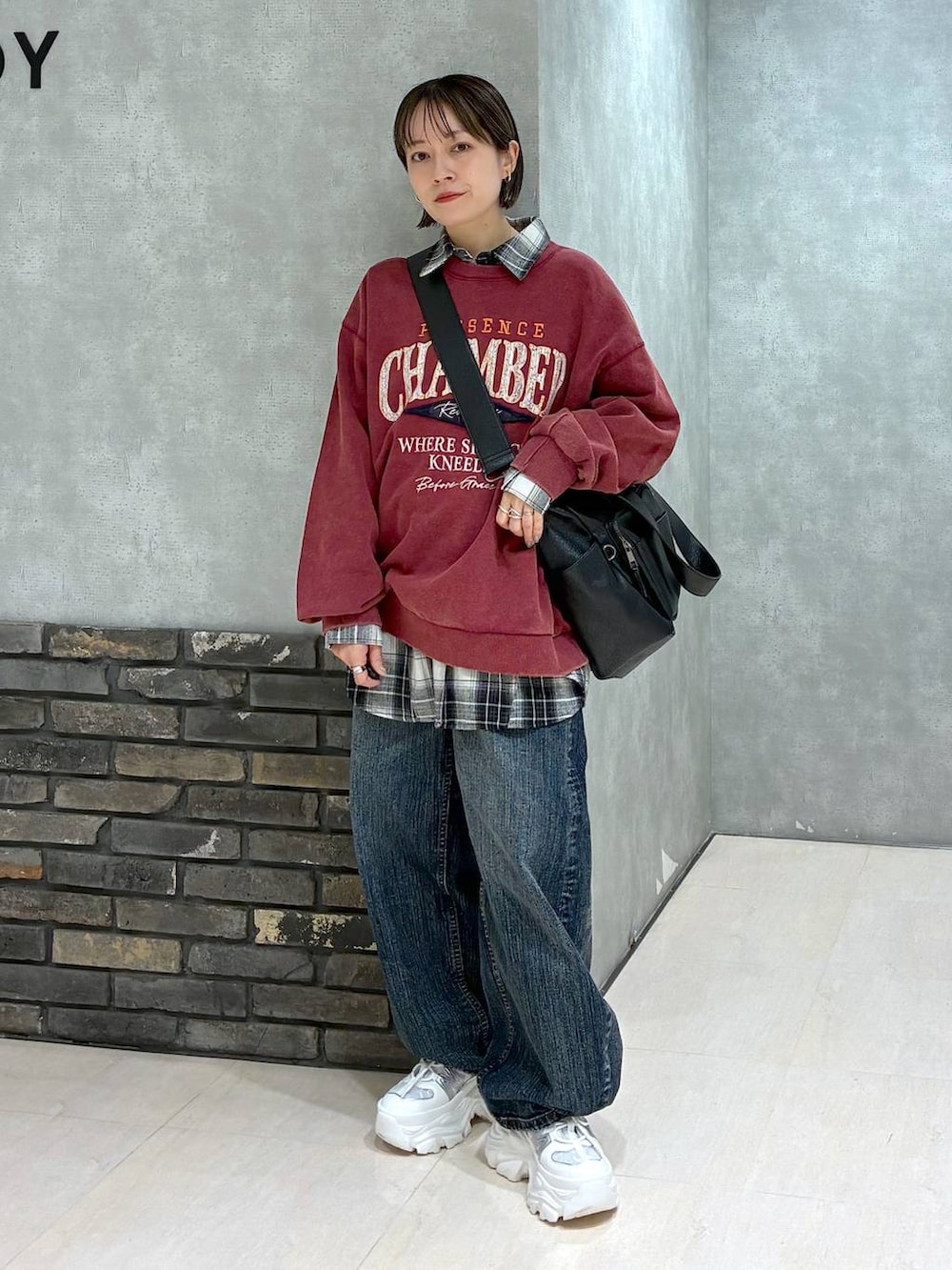 ホワイト系のスニーカー、ブラック系のボストンバッグ、レッド系のスウェットを着用したレディースの冬コーディネートの6枚目の写真