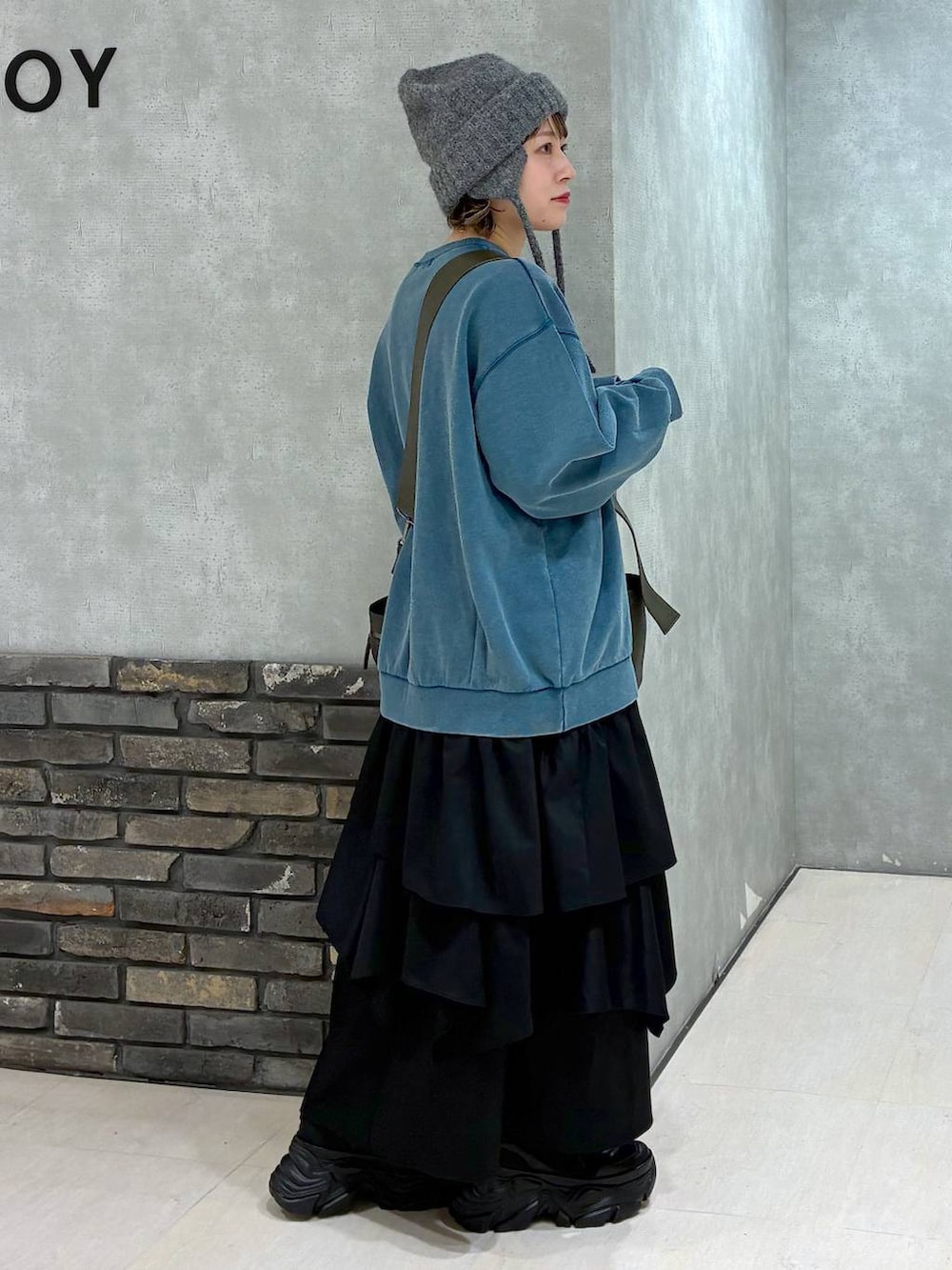 ブラック系のスニーカー、グリーン系のボストンバッグ、グリーン系のスウェットを着用したレディースの冬コーディネートの4枚目の写真