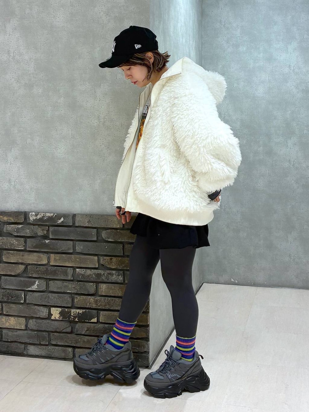 グレー系のスニーカー、ホワイト系のブルゾン、ブラック系のその他パンツを着用したレディースの冬コーディネートの7枚目の写真