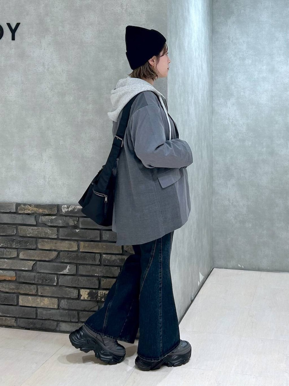 グレー系のスニーカー、ブルー系のデニムパンツ、グレー系のテーラードジャケットを着用したレディースの秋コーディネートの4枚目の写真