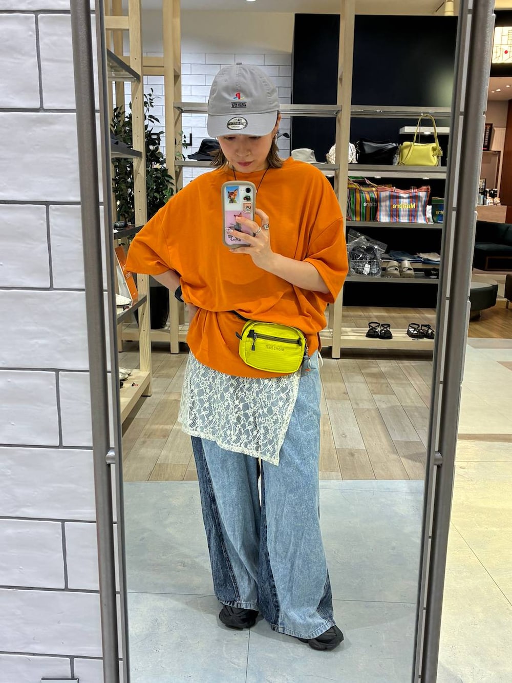ブルー系のデニムパンツ、オレンジ系のTシャツ/カットソーを着用したレディースの春コーディネートの3枚目の写真