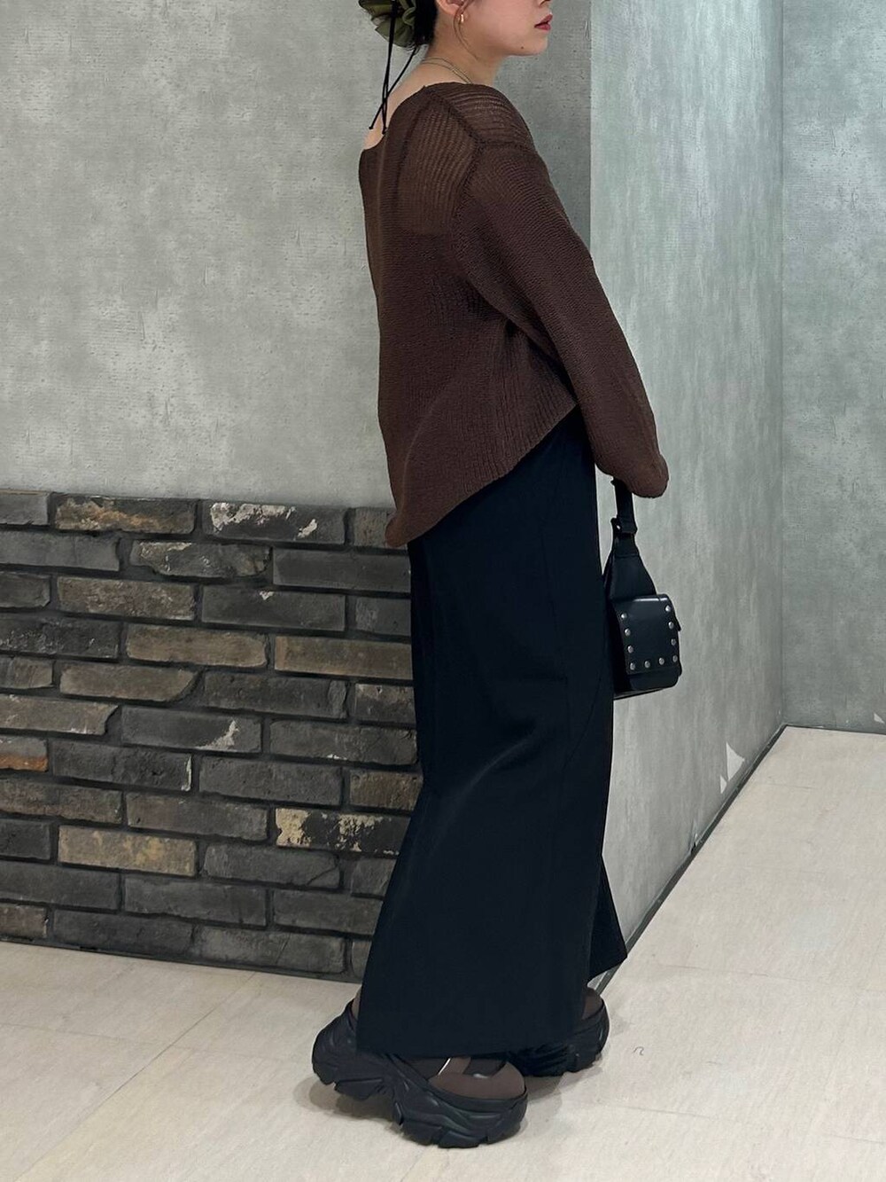 ブラウン系のブーツ、ブラック系のキャミソール、ブラウン系のニット/セーターを着用したレディースの秋コーディネートの5枚目の写真