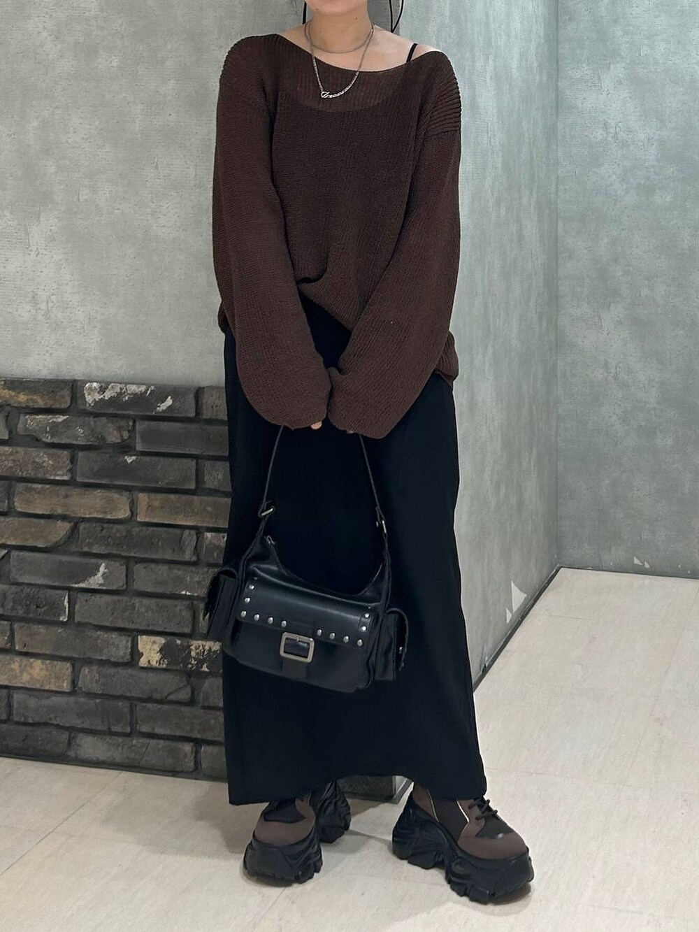 ブラウン系のブーツ、ブラック系のキャミソール、ブラウン系のニット/セーターを着用したレディースの秋コーディネートの6枚目の写真